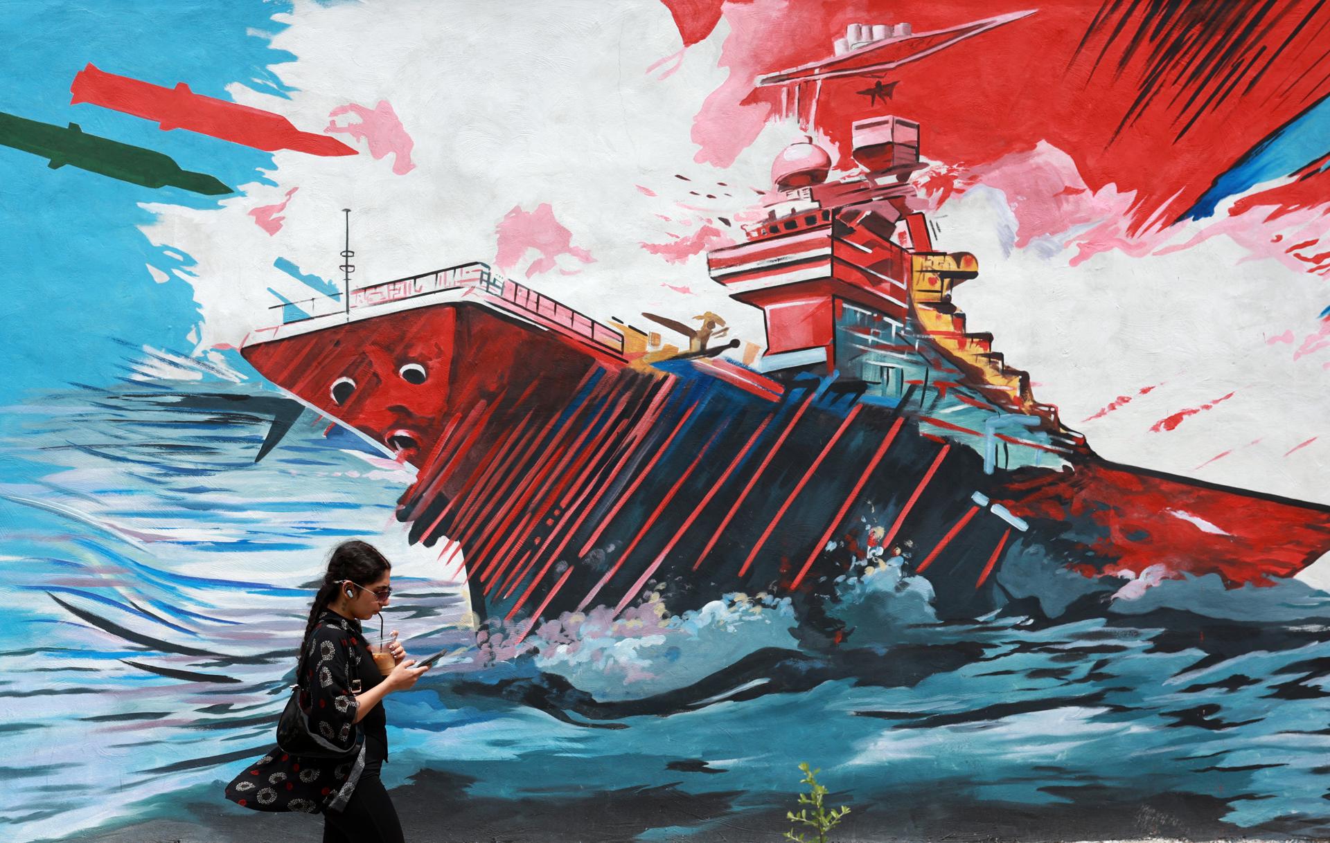 FOTODELDÍA TEHERÁN (Irán), 04/05/2026.- Una mujer iraní camina junto a un mural antiestadounidense en una calle de Teherán, Irán, este lunes. El portavoz del Ministerio de Relaciones Exteriores iraní, Esmaeil Baghaei, criticó los planes del presidente estadounidense sobre el paso de buques por el estrecho de Ormuz, un día después de que Donald Trump anunciara que Washington comenzaría a escoltar barcos a través de la vía marítima.EFE/ Abedin Taherkenareh