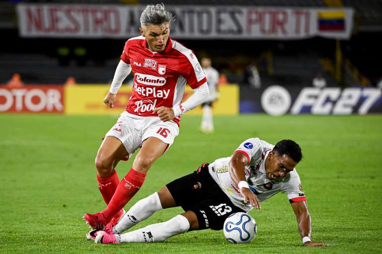 Daniel Torres elude a un rival durante el partido entre Santa Fe y Caracas en el estadio El Campín de Bogotá por los playoffs de la Copa Sudamericana 2026.