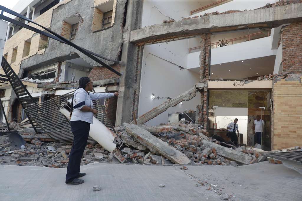 AME7645. CALI (COLOMBIA), 10/08/2026.- Personas caminan sobre los escombros de un edificio colapsado este lunes, en Cali (Colombia). Al menos 20 edificios sufrieron graves daños por consecuencia del terremoto de magnitud 7,4 que sacudió la mayor parte del país, con epicentro en la zona del Pacífico. EFE/ Ernesto Guzmán