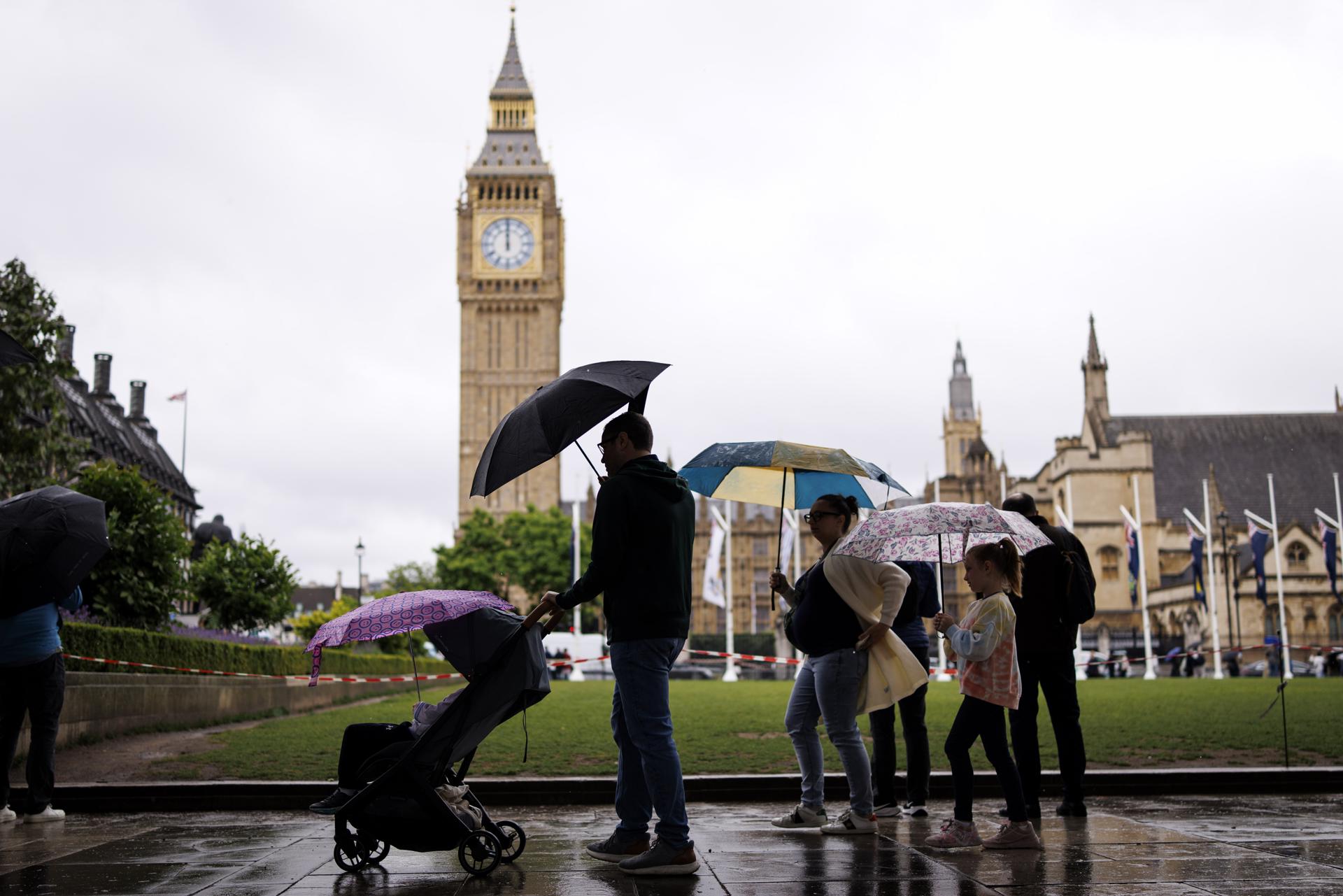 LONDON (United Kingdom), 03/06/2026.- A family uses umbrellas as they walk through Parliament Square in the rain in London, Britain, 03 June 2026. The UK is set for an unsettled weather period this week, with temperatures expected to fall by nearly 15 degrees from last week. (Reino Unido, Londres) EFE/EPA/TOLGA AKMEN