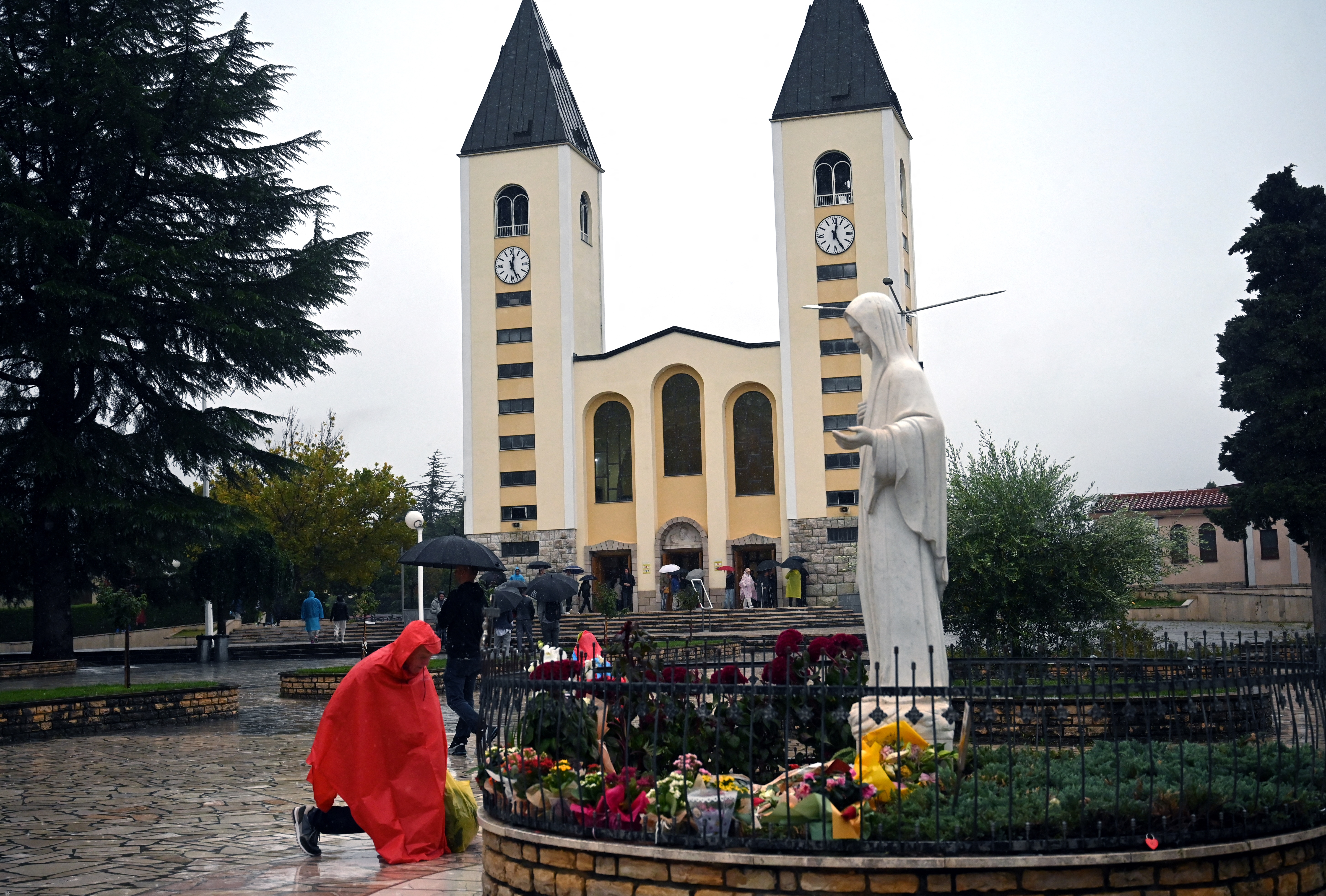 A man kneels in front of a statue depicting the Virgin Mary, in front of St. Jacob church, in Medjugorje, on September 19, 2024.
