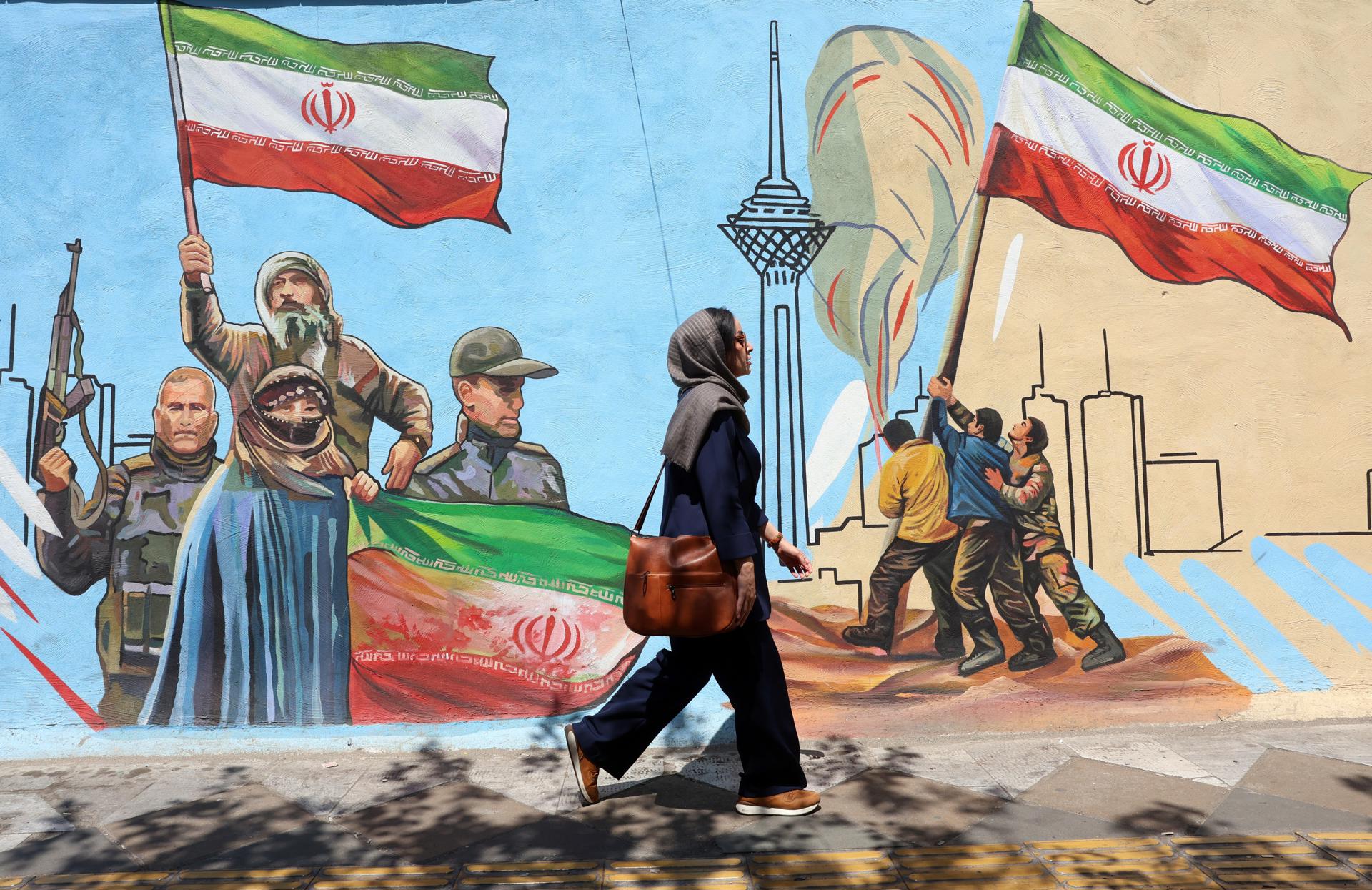 TEHRAN (IRAN(Islamic Republic Of)), 08/06/2026.- An Iranian woman walks past a mural on a street in Tehran, Iran, 08 June 2026. Iran and Israel exchanged fire after Iran launched missiles at Israel in retaliation for an earlier Israeli strike on Beirut's southern suburbs. Iran and Israel have targeted each other since a fragile US-brokered ceasefire went into effect in early April. (Teherán) EFE/EPA/ABEDIN TAHERKENAREH RESTRICTIONS: NO Access Israel Media/Persian Language TV Stations Outside Iran/Strictly No Access BBC Persian/VOA Persian/Manoto TV/Iran International TV. (As mandated by Iran's Directorate General for Foreign Media) --