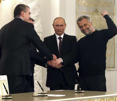 El presidente ruso, Vladimir Putin, une sus manos a las del primer ministro de Crimea, Serguéi Axionov (izq.), el presidente del Parlamento de Crimea, Vladimir Konstantinov, y el jefe de la administración de Sebastopol, Alexei Chaliy (der.). / EFE