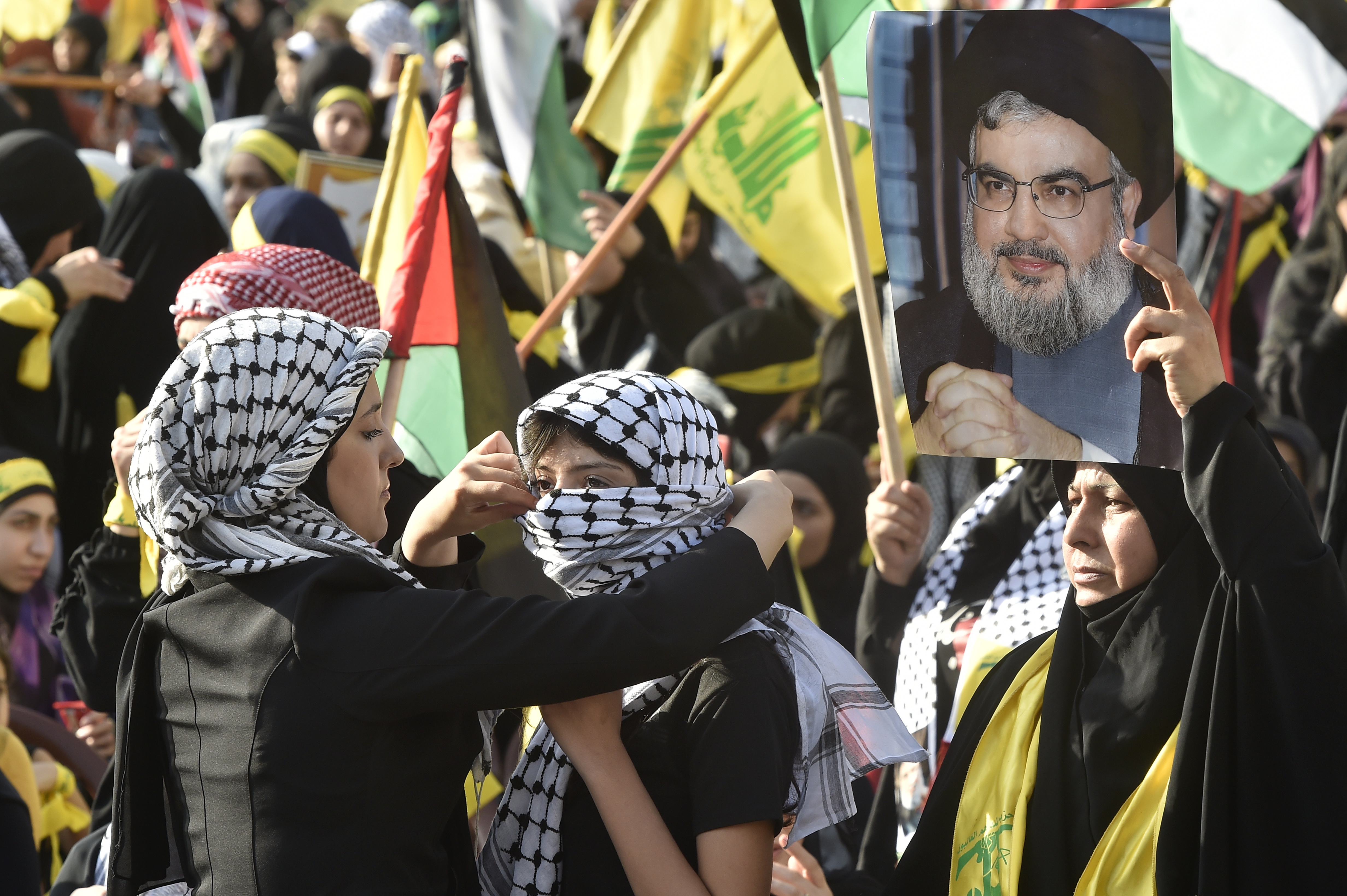 Beirut (Lebanon), 03/11/2023.- A supporter of Hezbollah adjusts her friend's Palestinian kofieh scarf during the speech of Hezbollah leader Hassan Nasrallah on a screen in the southern suburb of Beirut, Lebanon, 03 November 2023. Hezbollah chief Hassan Nasrallah gave his first speech since the Israel-Hamas conflict following an unprecedented attack carried out by Hamas militants from Gaza into Israel on 07 October 2023. (Líbano, Hizbulá/Hezbolá) EFE/EPA/WAEL HAMZEH