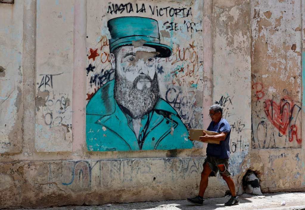 HAB01 LA HABANA (CUBA). – Una persona camina este jueves, junto a un grafiti del líder de la revolución cubana Fidel Castro, en La Habana (Cuba). EFE/ Ernesto Mastrascusa