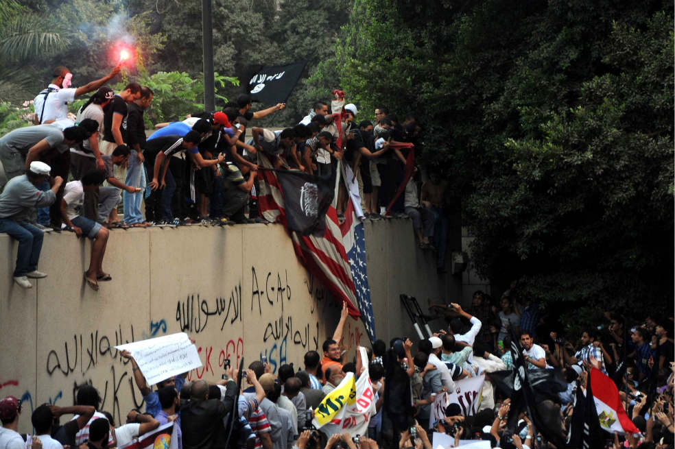 Manifestantes egipcios bajan la bandera de EE.UU. en la embajada norteamericana en El Cairo. / AFP