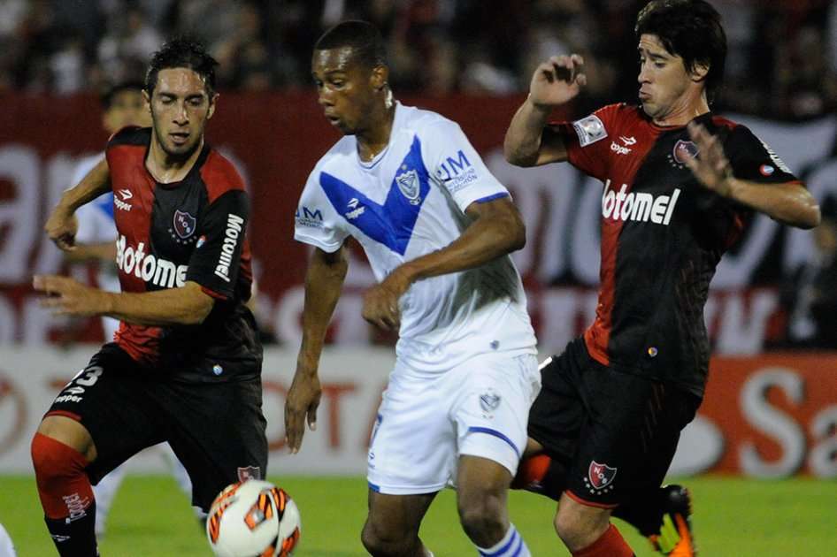 El colombiano Jonathan Copete disputa un balón con Hernán Villalba (i) y Pablo Pérez (d) de Newell's Old Boys.