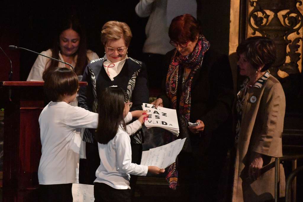 Dos integrantes del coro Hijos e Hijas de la Paz entregaron el mandato de paz a Gloria Inés Ramírez, ministra del Trabajo con funciones presidenciales; Patricia Ariza, ministra de Cultura; y Gloria Cuartas, directora de la Unidad de Implementación del Acuerdo de Paz.