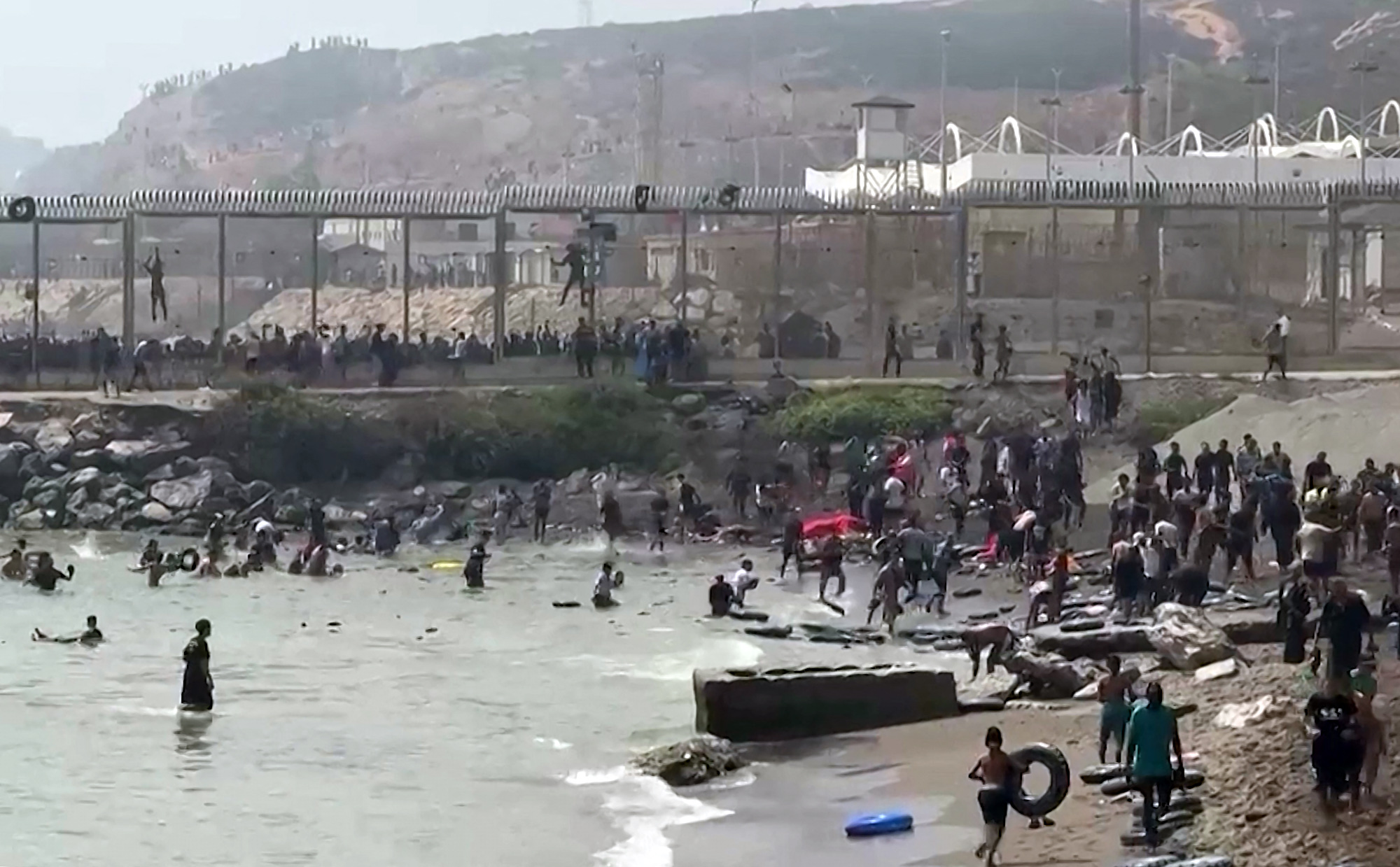 Esta captura de vídeo de AFP muestra a migrantes llegando a la costa del enclave español de Ceuta, en el norte de África, tras nadar alrededor de la valla fronteriza entre Marruecos y España, en Ceuta, el 30 de julio de 2026. /Lucia DIAZ / AFP