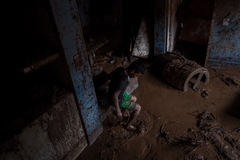 AME3286. TEJERIAS (VENEZUELA), 09/10/2022.- Un niño camina entre el lodo que quedó en su vivienda tras las lluvias y el desbordamiento de la quebrada (rio) Los Patos en Las Tejerias, estado Aragua (Venezuela). La crecida de una quebrada este sábado arrastró viviendas, mobiliario urbano, e inundó las calles de la localidad, arrasando con todo lo que el agua encontró a su paso. El Gobierno desplegó hoy organismos de salvamento, seguridad ciudadana, así como cuadrillas de mantenimiento y limpieza, y personal de diversas instituciones para "la atención integral del pueblo", dijo el presidente Nicolás Maduro a través de su cuenta de Twitter.EFE/ Rayner Peña R.