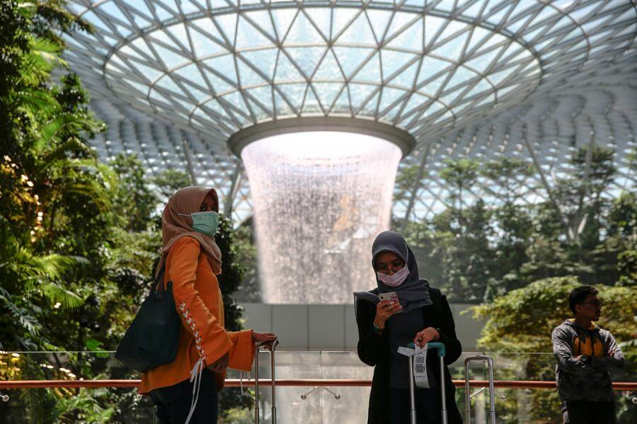Varias turistas que llevan mascarillas esperan en el Rain Vortex del aeropuerto Jewel Changi de Singapur. El Ministerio de Sanidad del país asiático ha informado sobre la existencia de 50 casos de pacientes infectados de coronavirus. / EFE/ Wallace Woon