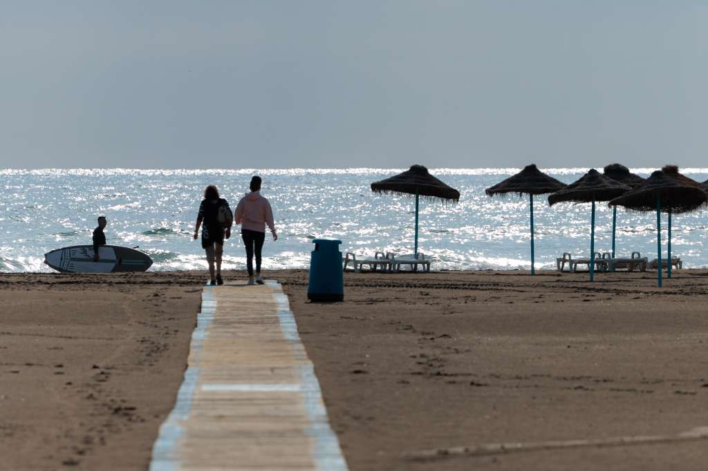 VALENCIA, 19/05/2023.- Varias personas pasean por la playa de la Malavarrosa de Valencia. La Comunitat Valenciana registrará este fin de semana chubascos que podrán ser localmente fuertes, más probables el sábado y de forma más ocasional el domingo, y con temperaturas máximas que serán algo más altas. EFE/Biel Aliño