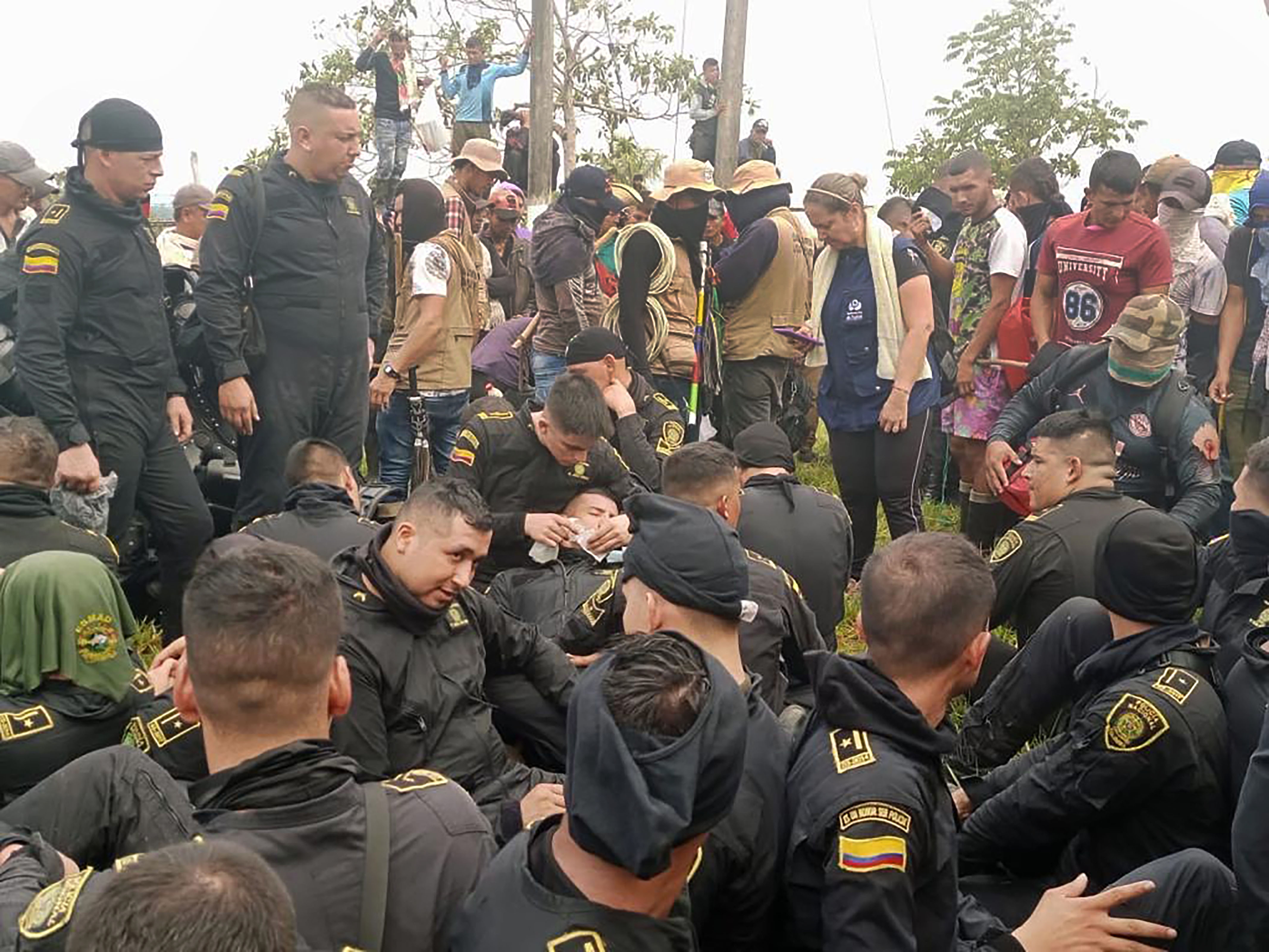 POZ400. LOS POZOS(COLOMBIA), 02/03/2023.- Fotografía cedida por la Defensoría del Pueblo que muestra a un grupo de policías que permanecen retenidos por un grupo de indígenas en la inspección Los Pozos de San Vicente del Caguán (Colombia). Al menos dos personas muertas dejaron este jueves enfrentamientos entre un grupo de indígenas y campesinos colombianos contra la fuerza pública que intenta contener una protesta frente a las instalaciones de la petrolera Emerald Energy en el departamento de Caquetá, en el sur del país. EFE/ Defensoría Del Pueblo / SOLO USO EDITORIAL/ SOLO DISPONIBLE PARA ILUSTRAR LA NOTICIA QUE ACOMPAÑA (CRÉDITO OBLIGATORIO)