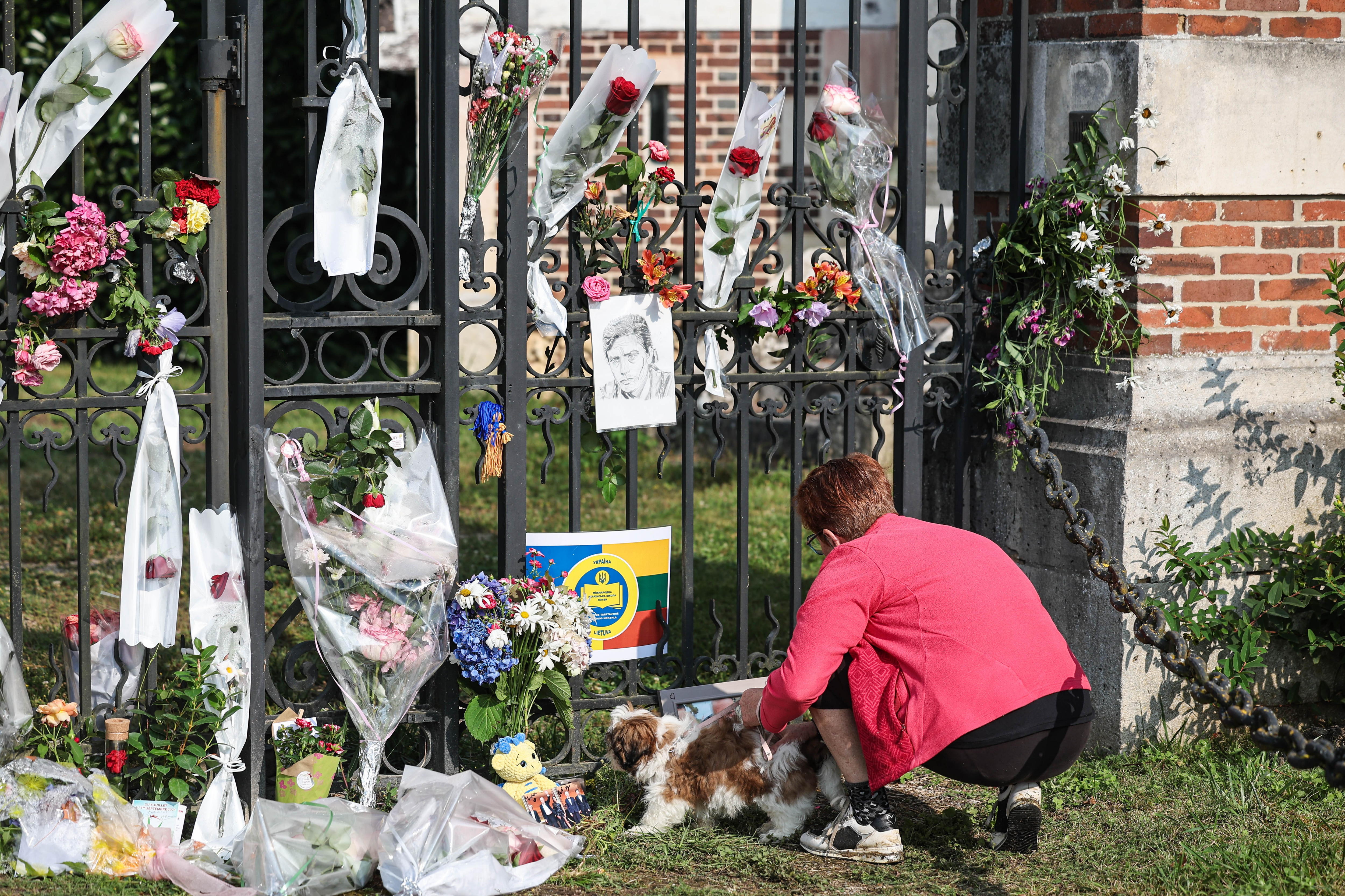 Douchy (France), 19/08/2024.- A woman lays flowers as villagers and fans pay tribute to late French actor Alain Delon, in front of his property in Douchy, France, 19 August 2024. French film legend Alain Delon passed away aged 88 in Duchy, France, his family said in a statement on 18 August. (Francia) EFE/EPA/CHRISTOPHE PETIT TESSON