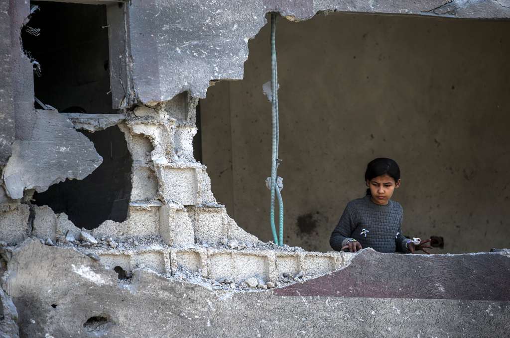 Al Nusairat Southern Gaza Strip (-), 20/03/2024.- A Palestinian little girl looks out of a damaged building while others check for missing people under the rubble of a destroyed house following an Israeli air strike, in Al Nusairat refugee camp, southern Gaza Strip, 20 March 2024. More than 31,500 Palestinians and over 1,300 Israelis have been killed, according to the Palestinian Health Ministry and the Israel Defense Forces (IDF), since Hamas militants launched an attack against Israel from the Gaza Strip on 07 October 2023, and the Israeli operations in Gaza and the West Bank which followed it. EFE/EPA/MOHAMMED SABER