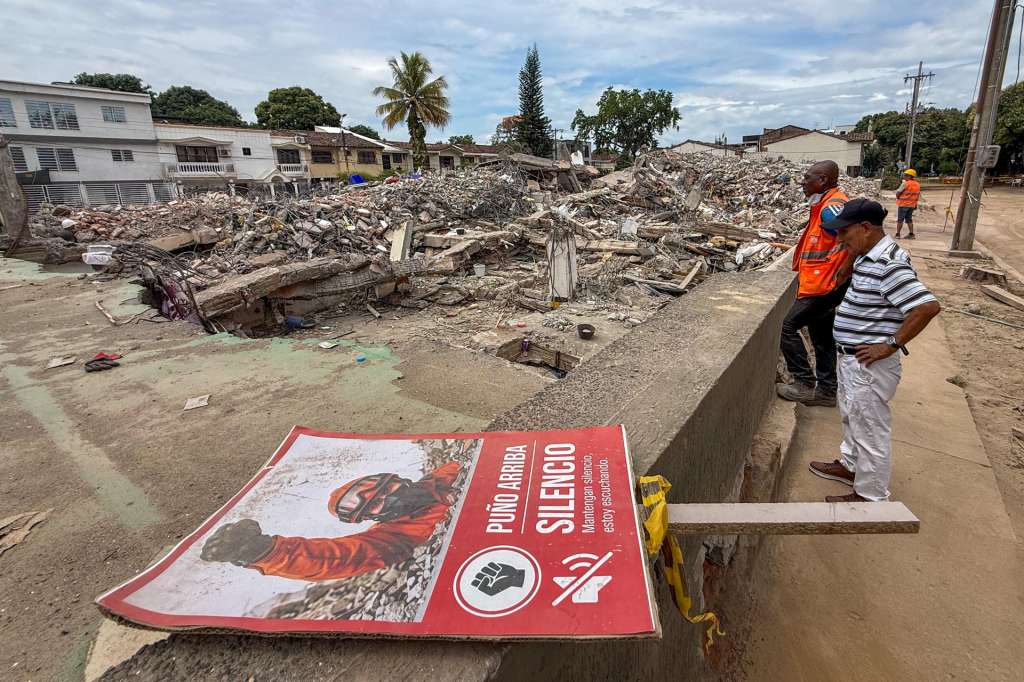 AME1243. CALI (COLOMBIA), 22/08/2026.- Personas observan escombros del edificio Torres del Limonar este sábado, afectado por el terremoto del 10 de agosto, en Cali (Colombia). En los 46 puntos donde edificaciones colapsaron tras el terremoto de magnitud 7,4 que sacudió a Cali, ya no se buscan sobrevivientes, ahora la maquinaria que durante días removió toneladas de concreto y hierro trabaja en otra tarea: retirar los restos de una ciudad golpeada por la tragedia y abrir paso a la reconstrucción. EFE/ Mario Baos
