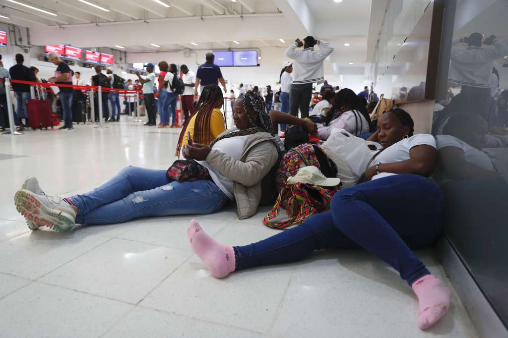 AME7341. CALI (COLOMBIA), 30/03/2023.- Personas descansan sobre sus maletas a la espera de una solución para un vuelo con destino a la isla de San Andrés que fue cancelado por la aerolínea Ultra Air, luego de suspender operaciones en Colombia, hoy en el Aeropuerto Alfonso Bonilla Aragón en Cali (Colombia). EFE/Ernesto Guzmán