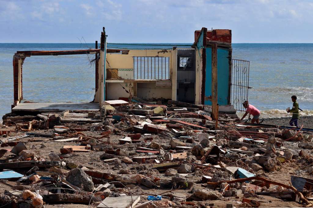 FOTODELDÍA ACOMPAÑA CRÓNICA: CUBA HURACANES ATLÁNTICO AME3838. GUAMÁ (CUBA), 30/10/2025.- Personas caminan frente a una casa destruida, este jueves en el poblado de Guamá, Santiago de Cuba (Cuba). Según el Instituto de Meteorología, en apenas 15 horas Melissa dejó hasta 400 milímetros de agua (o litros por metro cuadrado) en seis localidades, entre 200 y 300 milímetros en doce localidades y más de 100 milímetros en 72 localidades. EFE/ Ernesto Mastrascusa