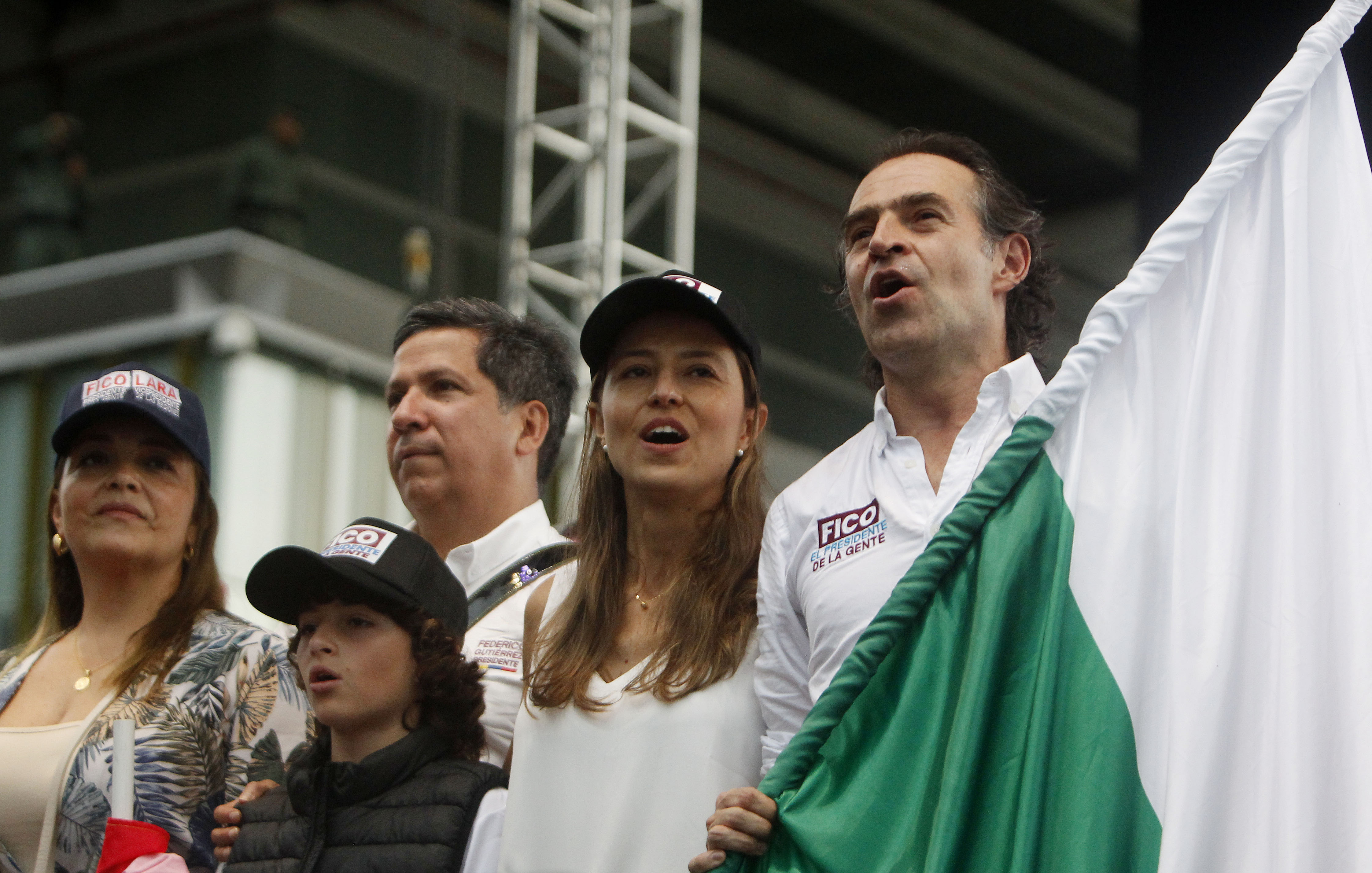 AME1612. MEDELLÍN (COLOMBIA), 22/05/2022.- El candidato a la Presidencia de Colombia Federico "Fico" Gutiérrez, de la coalición de Equipo por Colombia, canta el himno de Antioquia junto a su esposa Margarita Gómez (2-d) y su formula vicepresidencial Rodrigo Lara Sánchez (2-i), durante su evento de cierre de campaña, hoy, en Medellín (Colombia). EFE/ Luis Eduardo Noriega A.