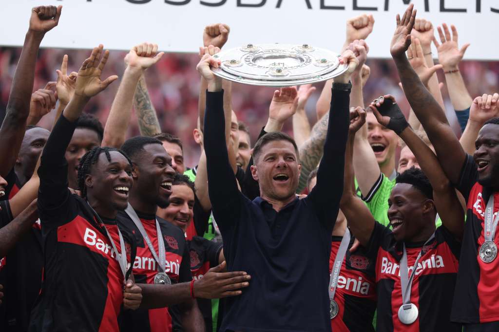 Leverkusen (Germany), 18/05/2024.- Leverkusen's head coach Xabi Alonso (C) lifts the Bundesliga trophy (Meisterschale) flanked by his players after the German Bundesliga soccer match of Bayer 04 Leverkusen against FC Augsburg, in Leverkusen, Germany, 18 May 2024. (Alemania) EFE/EPA/CHRISTOPHER NEUNDORF CONDITIONS - ATTENTION: The DFL regulations prohibit any use of photographs as image sequences and/or quasi-video.