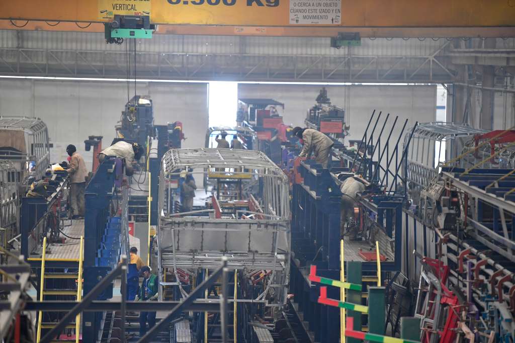 Obreros ensamblan la carrocería de un bus producido en la planta.
