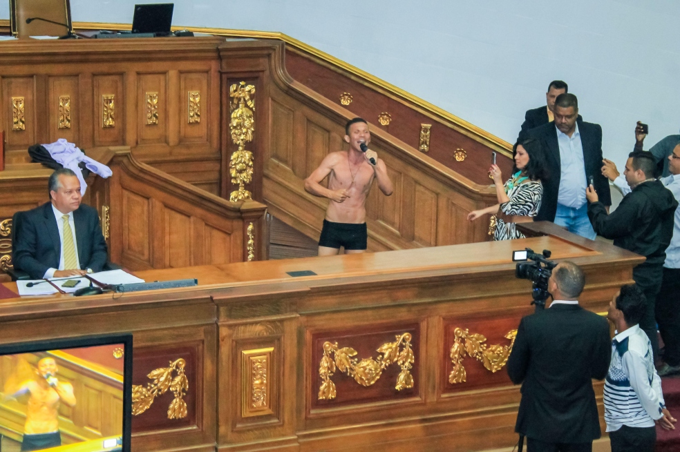 El diputado Gilber Caro mientras se desnuda durante su intervención en el hemiciclo de sesiones hoy, martes 14 de agosto de 2018, en Caracas (Venezuela). / EFE