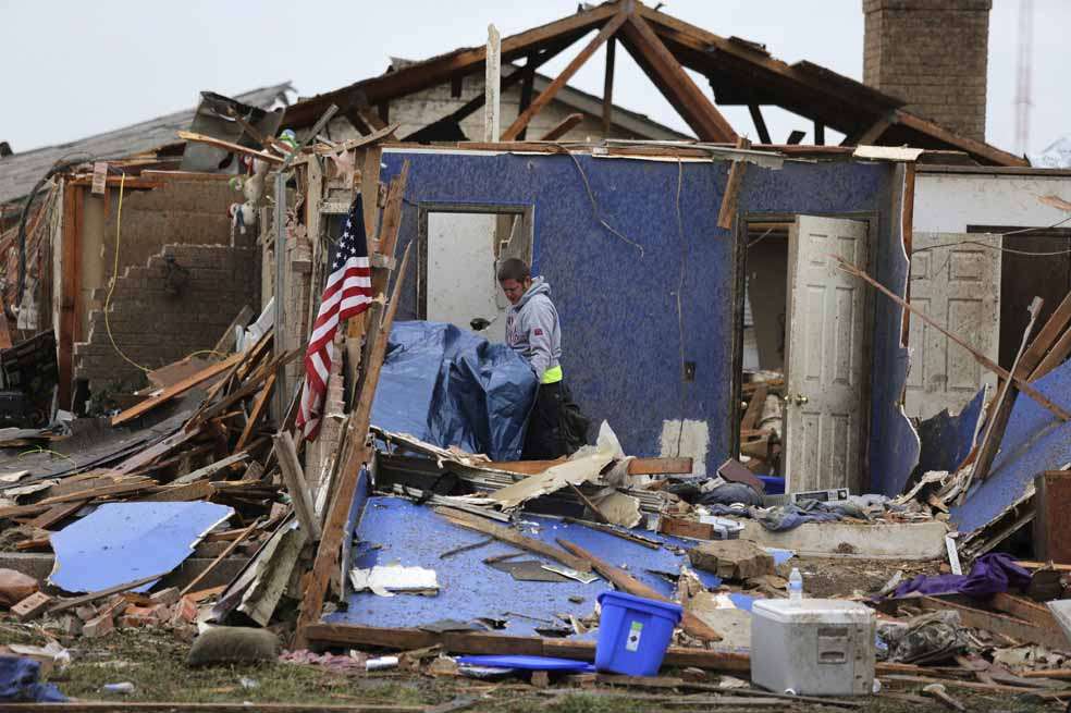Un hombre recupera algunos objetos de entre los escombros de una vivienda destruida en el barrio de Moore (sur de Oklahoma), Estados Unidos. / EFE