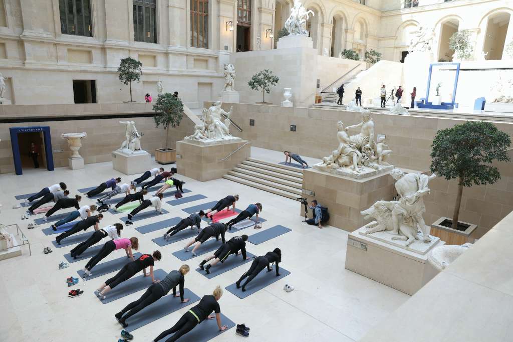 People take part in a rehearsal of "Les visites sportives", an experience proposed by artist and choreographer Mehdi Kerkouche in the Cour Marly at the Louvre Museum in Paris on April 23, 2024.