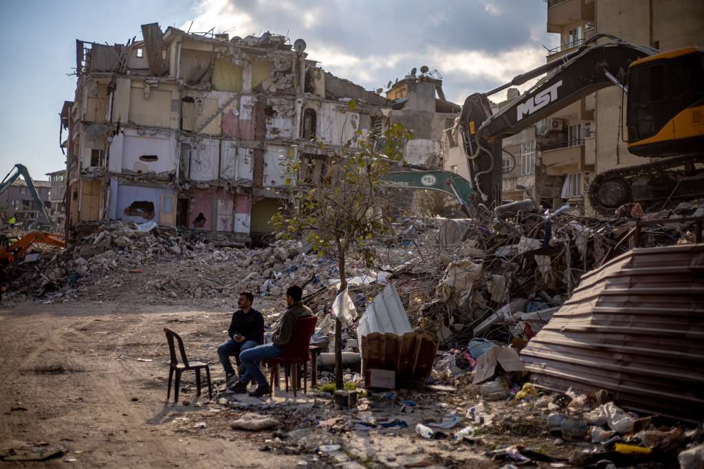 Hatay (antakya) (Turkey), 19/02/2023.- Men sit in front of collapsed buildings after a powerful earthquake, in Hatay, Turkey, 19 February 2023. More than 46,000 people have died and thousands more are injured after two major earthquakes struck southern Turkey and northern Syria on 06 February. Authorities fear the death toll will keep climbing as rescuers look for survivors across the region. (Terremoto/sismo, Siria, Turquía, Estados Unidos) EFE/EPA/MARTIN DIVISEK