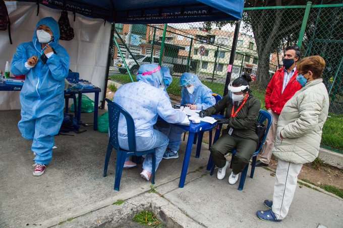 Una mujer y un hombre esperan de pie el registro para tomar la prueba de COVID-19.