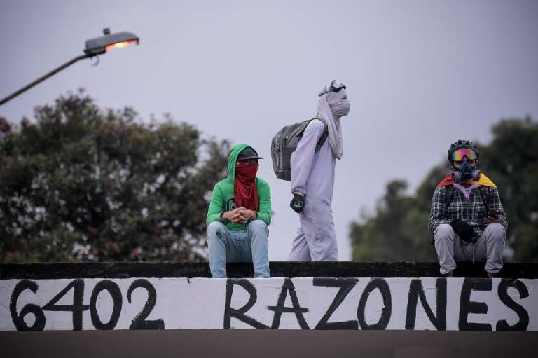 Encapuchados en el techo de la entrada a la Universidad Nacional.