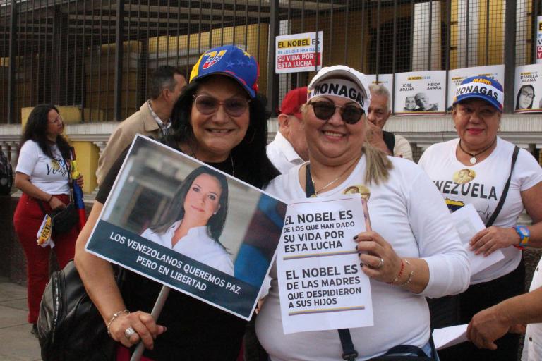 AME6443. LIMA (PERÚ), 06/12/2025.- Mujeres sostienen carteles durante la marcha "por la paz y la libertad" en Venezuela este sábado, en Lima (Perú). EFE/ Paula Bayarte