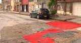 Con alfombras tapan huecos en barrio de Bogotá