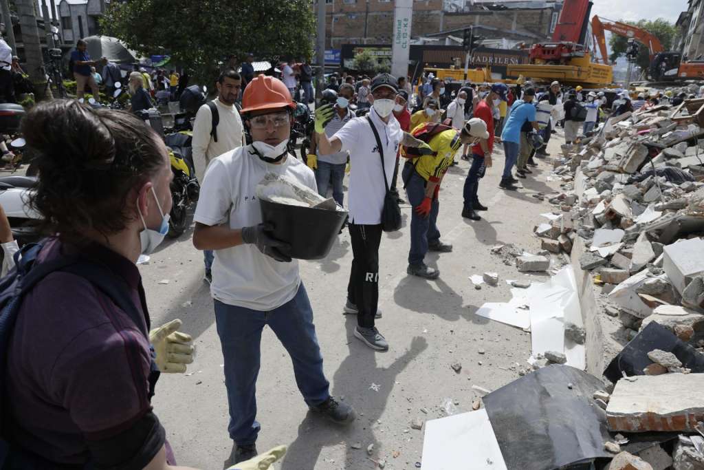 AME8355. PEREIRA (COLOMBIA), 12/08/2026.- Voluntarios realizan una cadena humana para sacar escombros de edificaciones destruidas por el terremoto de magnitud 7,4 del pasado lunes, este miércoles en Pereira (Colombia). EFE/ Carlos Ortega