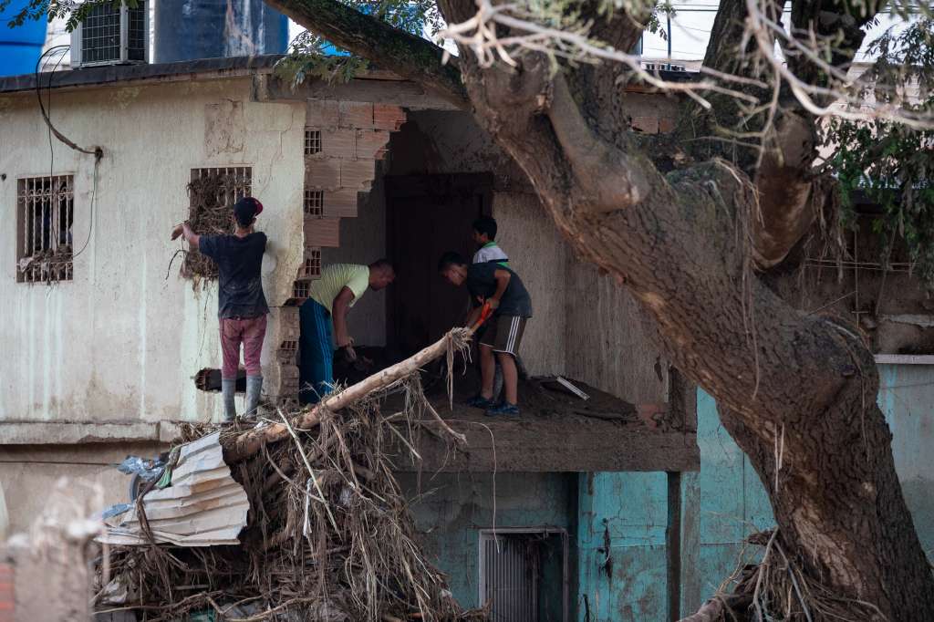 AME3304. LAS TEJERÍAS (VENEZUELA), 09/10/2022.- Personas retiran hoy de su hogar los restos dejados por el desbordamiento de la quebrada Los Patos en Las Tejerías, estado Aragua (Venezuela). La crecida de una quebrada este sábado arrastró viviendas, mobiliario urbano, e inundó las calles de la localidad, arrasando con todo lo que el agua encontró a su paso. El Gobierno desplegó hoy organismos de salvamento, seguridad ciudadana, así como cuadrillas de mantenimiento y limpieza, y personal de diversas instituciones para "la atención integral del pueblo", dijo el presidente Nicolás Maduro a través de su cuenta de Twitter. EFE/ Rayner Peña R
