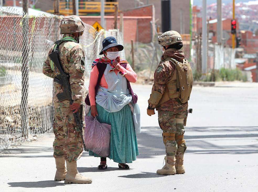 Militares bolivianos realizan la revisión del número en que terminan los carnés de identidad de ciudadanos, para comprar alimentos y productos básicos. / EFE/Martín Alipaz