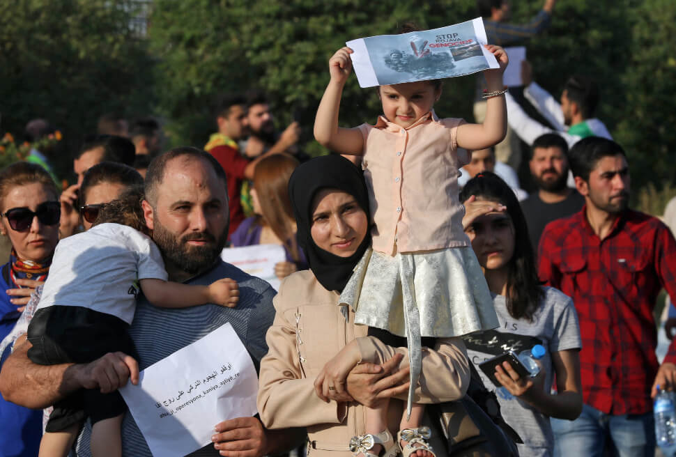 Una familia de kurdos, en Irbil, protesta contra la operación militar turca al norte de Siria. / AFP
