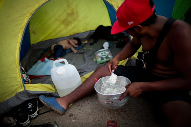 -FOTOGALERÍA- AME4250. BAJO CHIQUITO (PANAMÁ), 21/03/2023.- Yohandry Andrade, un migrante venezolano de 22 años, le sirve comida a su hijo en la comunidad de Bajo Chiquito tras días de caminar por la selva, el 10 de marzo de 2023, en Darién (Panamá). "Guerreros", repiten las madres, hijos guerreros que han aguantado largas caminatas, hambre, sed, el calor, picaduras de insectos, superar ríos y cerros, para sobrevivir a la selva del Darién en su ruta hacia Estados Unidos. Recién salidos de esta selva que hace de frontera natural entre Colombia y Panamá, los migrantes llegan hasta la conocida como Quebrada del León, donde les esperan unas piraguas de indígenas que los descenderán por el casi seco río Tuquesa hasta Bajo Chiquito, una pequeña población emberá donde podrán al fin reposar tranquilos. EFE/ Bienvenido Velasco