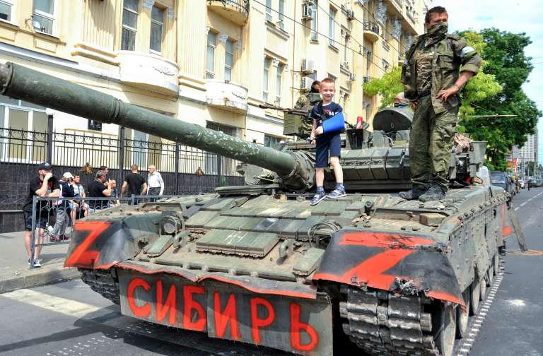 Rostov-on-don (Russian Federation), 23/06/2023.- A child poses for a photo on a tank reading 'Siberia' as servicemen from private military company (PMC) Wagner Group block a street in downtown Rostov-on-Don, southern Russia, 24 June 2023. Security and armoured vehicles were deployed after Wagner Group's chief Yevgeny Prigozhin said in a video that his troops had occupied the building of the headquarters of the Southern Military District, demanding a meeting with Russia'Äôs defense chiefs. (Rusia, Ucrania) EFE/EPA/ARKADY BUDNITSKY