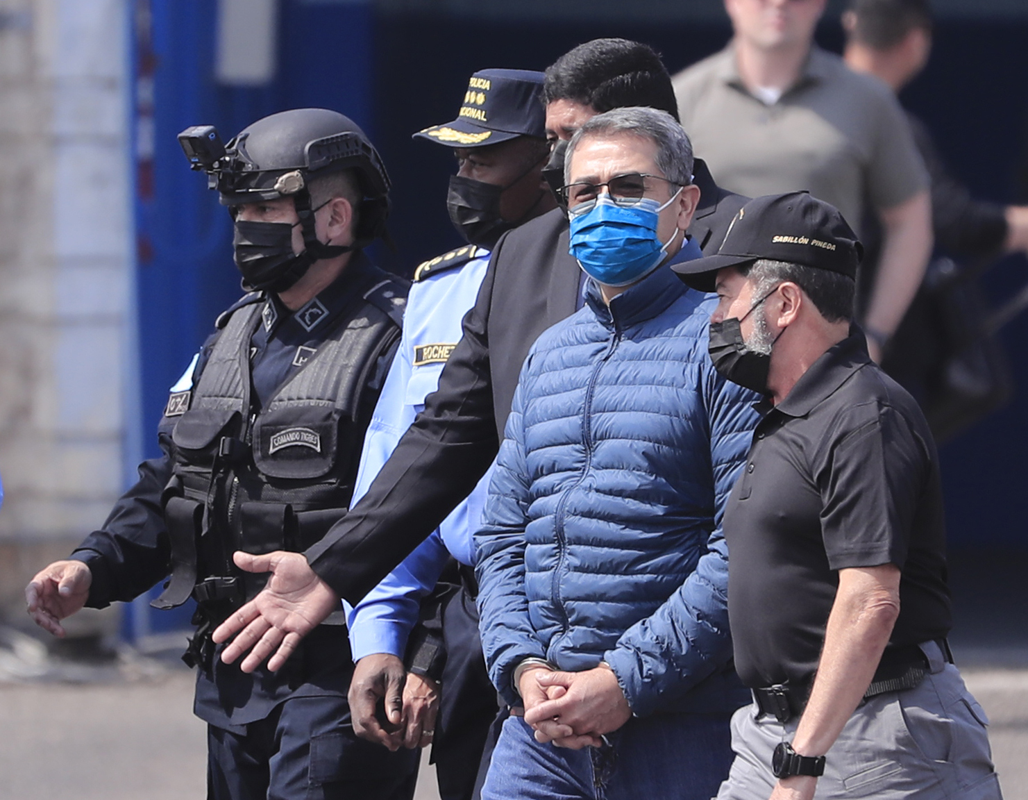 HON01. TEGUCIGALPA (HONDURAS), 21/04/2022.- El expresidente hondureño Juan Orlando Hernández es dirigido a la aeronave que lo llevará extraditado a los Estados Unidos hoy, en la base aérea Hernán Acosta de Tegucigalpa (Honduras). EFE/ Gustavo Amador