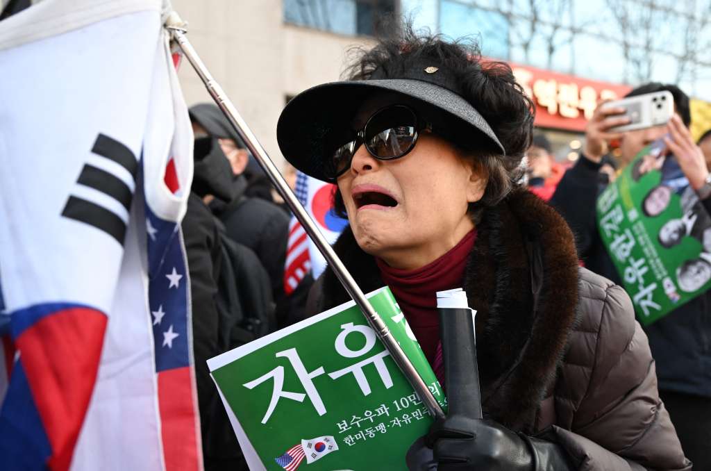 Partidarios del expresidente surcoreano destituido, Yoon Suk Yeol, reaccionan mientras ven una transmisión en vivo del juicio contra Yoon por sus cargos de insurrección cerca del Tribunal del Distrito Central de Seúl, el 19 de febrero de 2026.