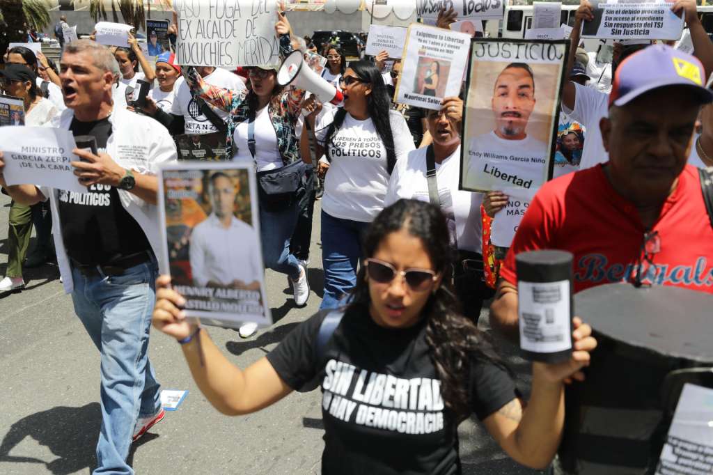 AME3711. CARACAS (VENEZUELA), 01/09/2026.- Personas sostienen carteles con imágenes de sus familiares, este martes durante en una manifestación en Caracas (Venezuela). La ONG Foro Penal indicó que en Venezuela hay 328 presos políticos, de los cuales 317 son hombres y 11 son mujeres, según un boletín con fecha de corte hasta el pasado 31 de agosto.EFE/ Ronald Peña R