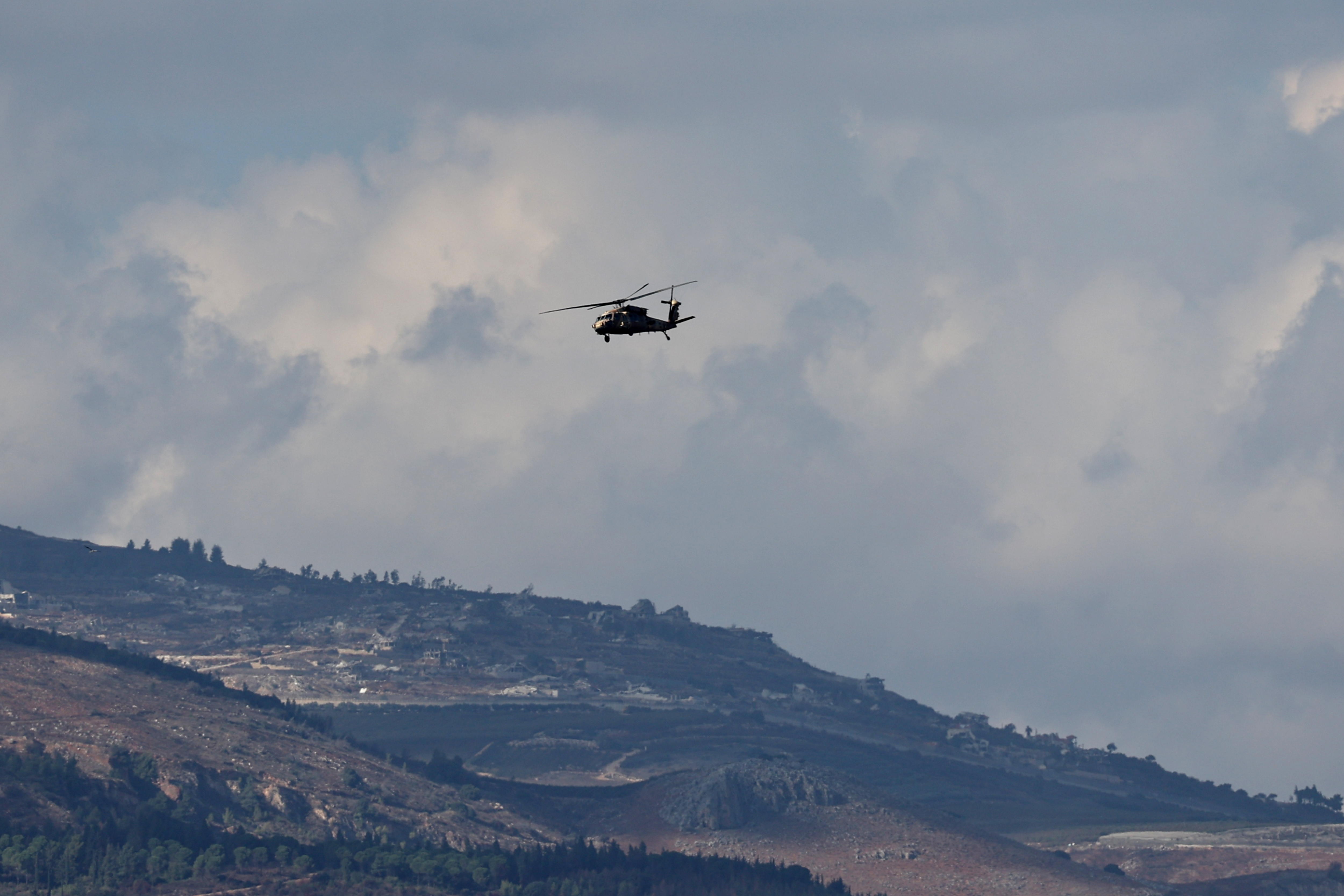 Kyriat Shomna (Israel), 20/11/2024.- An Israeli military helicopter flies over the northern border with Lebanon with the background of the Lebanese village of Odaisseh on 20 November 2024. The Israeli army stated that sirens sounded in the Upper and Western Galilee regions as approximately 25 projectiles were identified as crossing from Lebanon into Israeli territory with some being intercepted. According to the Lebanese Ministry of Health, more than 3,500 people have been killed and more than 14,900 injured in Lebanon since the escalation in hostilities between Israel and Hezbollah. (Líbano, Hizbulá/Hezbolá) EFE/EPA/ATEF SAFADI