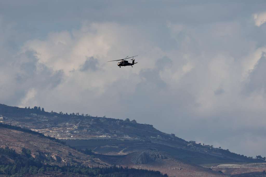Kyriat Shomna (Israel), 20/11/2024.- An Israeli military helicopter flies over the northern border with Lebanon with the background of the Lebanese village of Odaisseh on 20 November 2024. The Israeli army stated that sirens sounded in the Upper and Western Galilee regions as approximately 25 projectiles were identified as crossing from Lebanon into Israeli territory with some being intercepted. According to the Lebanese Ministry of Health, more than 3,500 people have been killed and more than 14,900 injured in Lebanon since the escalation in hostilities between Israel and Hezbollah. (Líbano, Hizbulá/Hezbolá) EFE/EPA/ATEF SAFADI