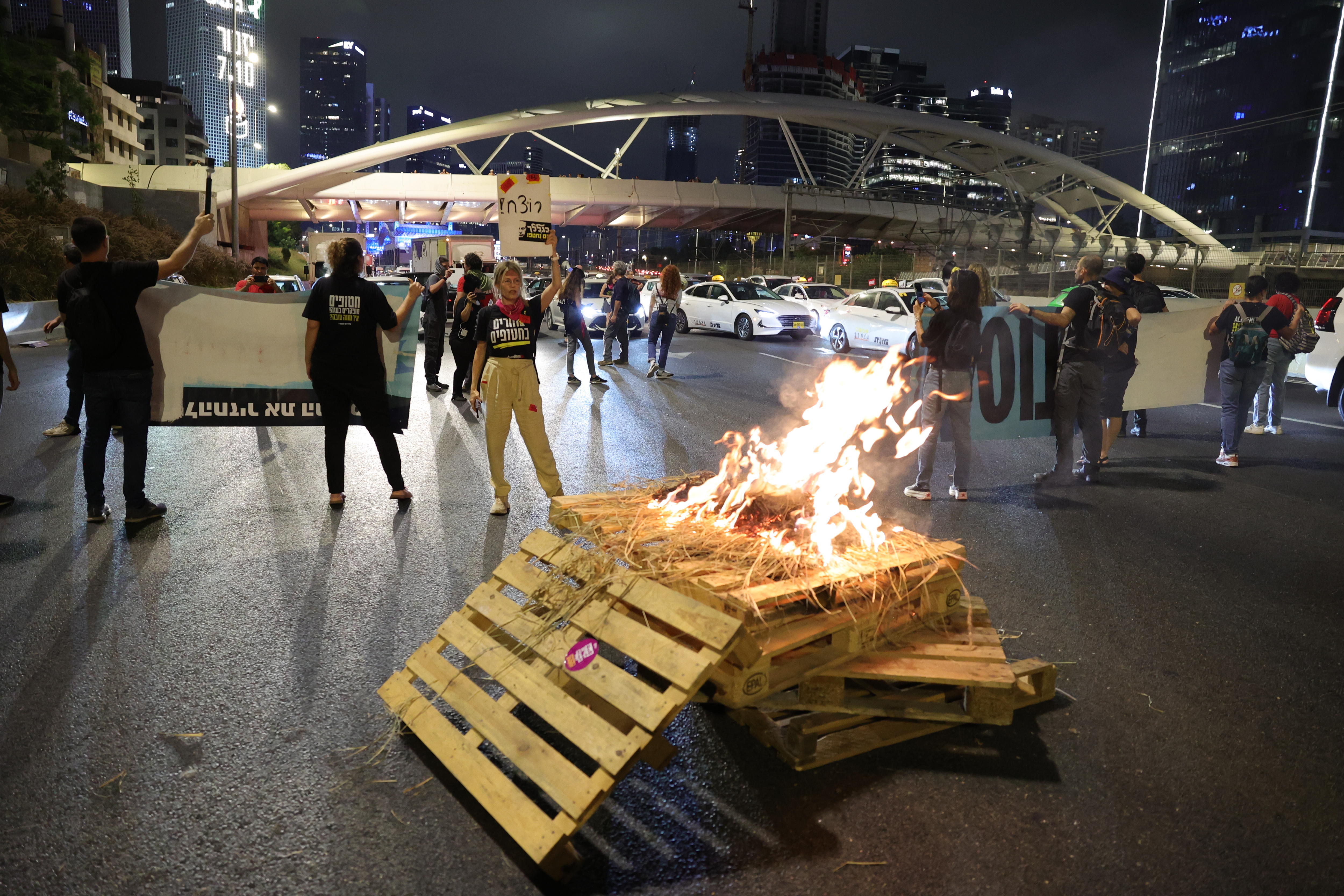 Tel Aviv (Israel), 05/10/2024.- Protesters block Ayalon highway and set up a bonfire calling for a ceasefire and for the release of Israeli hostages held by Hamas in Gaza, near the Kirya in Tel Aviv, Israel, 05 October 2024. According to a statement by the Israeli Government Press Office, 97 Israeli hostages remain in captivity in the Gaza Strip, including bodies of 33 confirmed dead. (Protestas) EFE/EPA/ABIR SULTAN