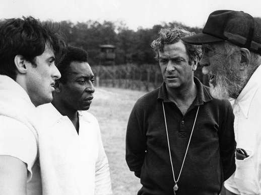 Sylvester Stallone, Pelé, Michael Caine y el director John Huston, en la filmación de la película "Escape a la victoria" de 1981.