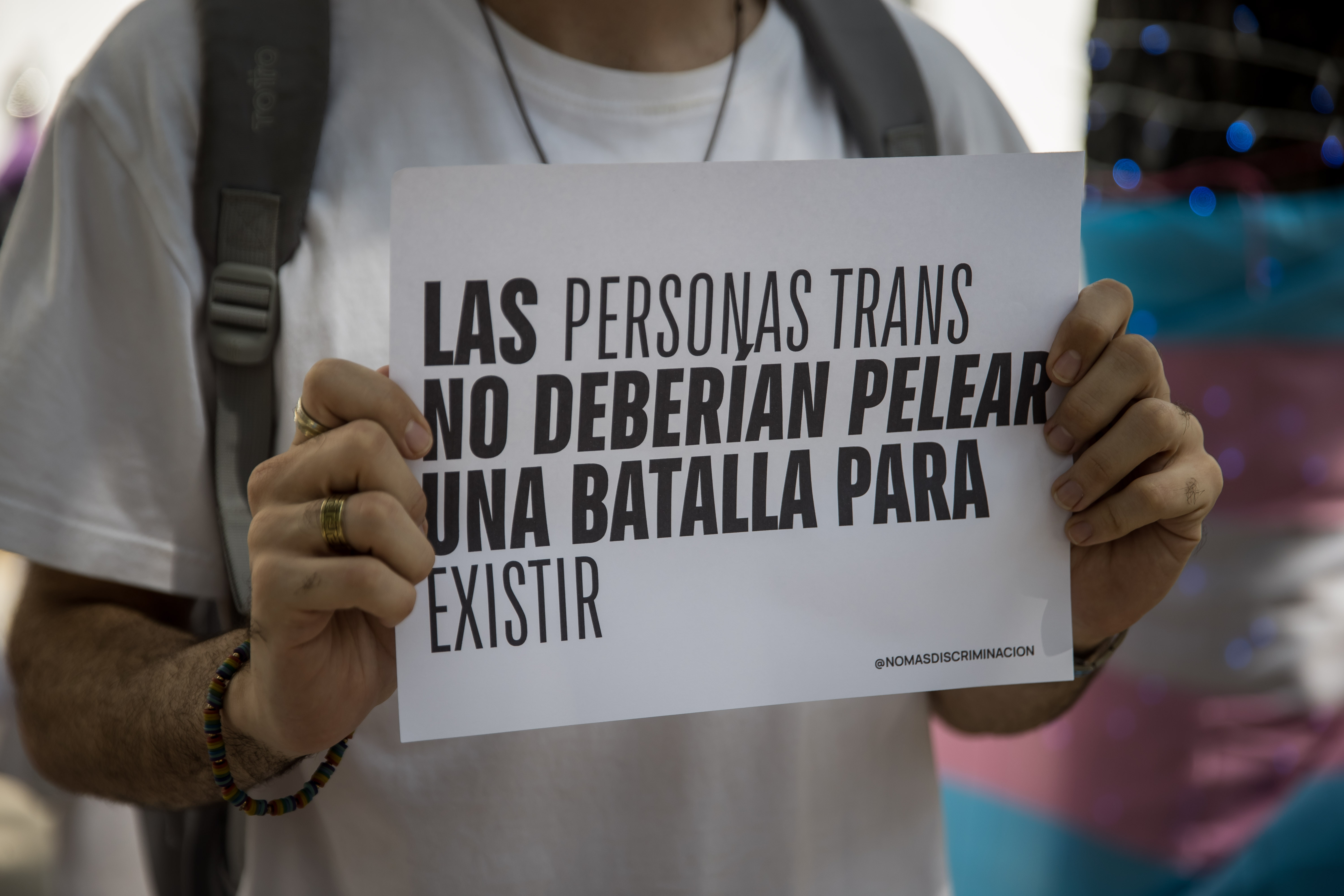 AME8415. CARACAS (VENEZUELA), 20/11/2023.- Una persona participa en una manifestación en las inmediaciones del Ministerio Público, hoy, en Caracas (Venezuela). Al menos 93 mujeres transexuales fueron asesinadas en Venezuela desde 2008 hasta la fecha, cuatro de ellas en lo que va de 2023, denunció este lunes el Observatorio Venezolano de Violencias LGBTIQ+, durante una protesta frente al Ministerio Público (MP, Fiscalía), en Caracas, con motivo del Día Internacional de la Memoria Trans. Varias camisetas blancas con nombres de mujeres trans en negro y la palabra 'asesinada' en rojo colgaban de una cuerda, y a un lado algunos de los manifestantes sostenían pancartas con mensajes como "Nuestras vidas importan" y "Mi orgullo es más fuerte". EFE/ Miguel Gutiérrez