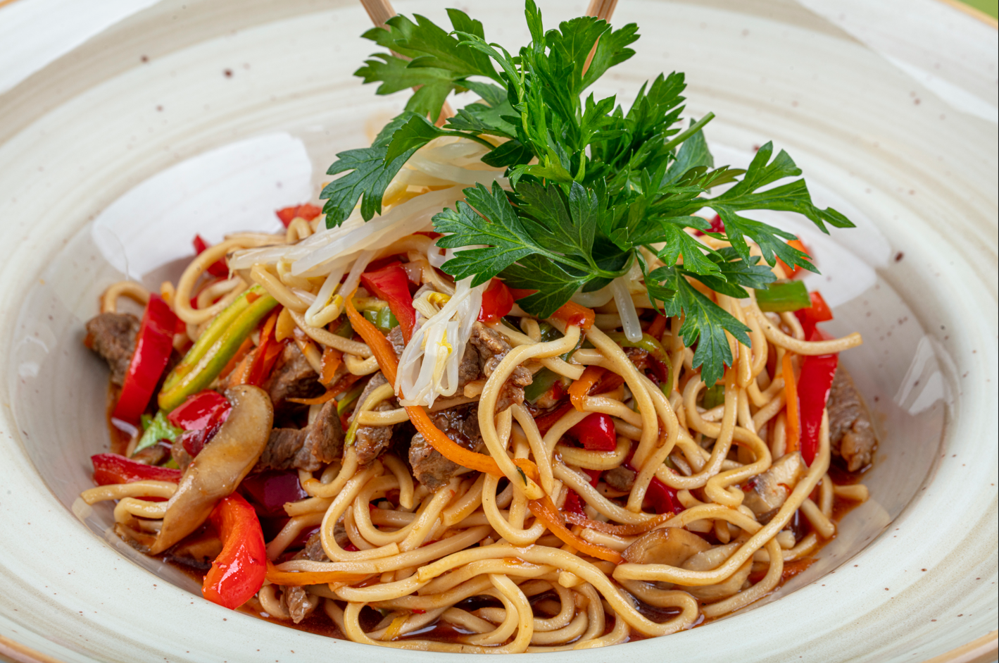 Espaguetis con vegetales en salsa picante y lomito de res