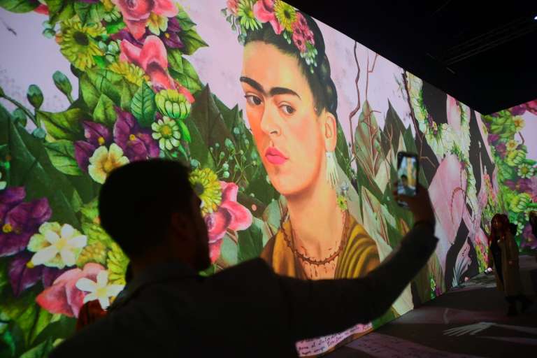 Uno de los asistentes se toma una “selfie” junto a una de las imágenes de Frida Kahlo, durante la inauguración para medios que se realizó el 11 de julio.