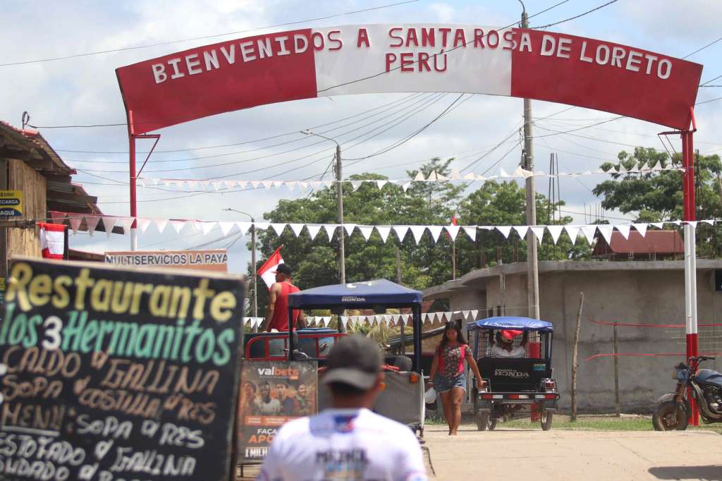 AME8356. SANTA ROSA (PERÚ), 07/08/2025.- Personas se movilizan en una calle que muestra un letrero fronterizo este miércoles, en la población de Santa Rosa, una isla en medio del río Amazonas bajo soberanía peruana, situada frente a la ciudad colombiana de Leticia, en la triple frontera amazónica con Brasil. Las banderas peruanas relucen por las escasas calles de Santa Rosa, la pequeña población objeto de controversia entre Colombia y Perú después de que el presidente colombiano, Gustavo Petro, acusara al Gobierno peruano de "apropiarse" ahora de un terreno que hace al menos medio siglo habitado como una parte más de Perú. EFE/ Stringer